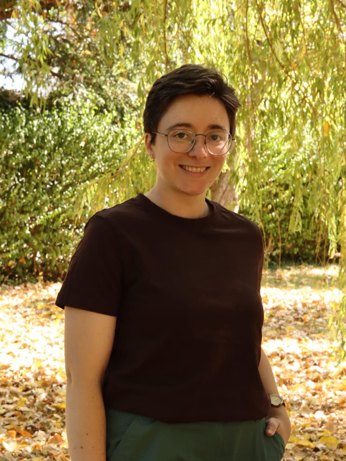 Ffion standing outdoors under a willow tree, smiling at the camera