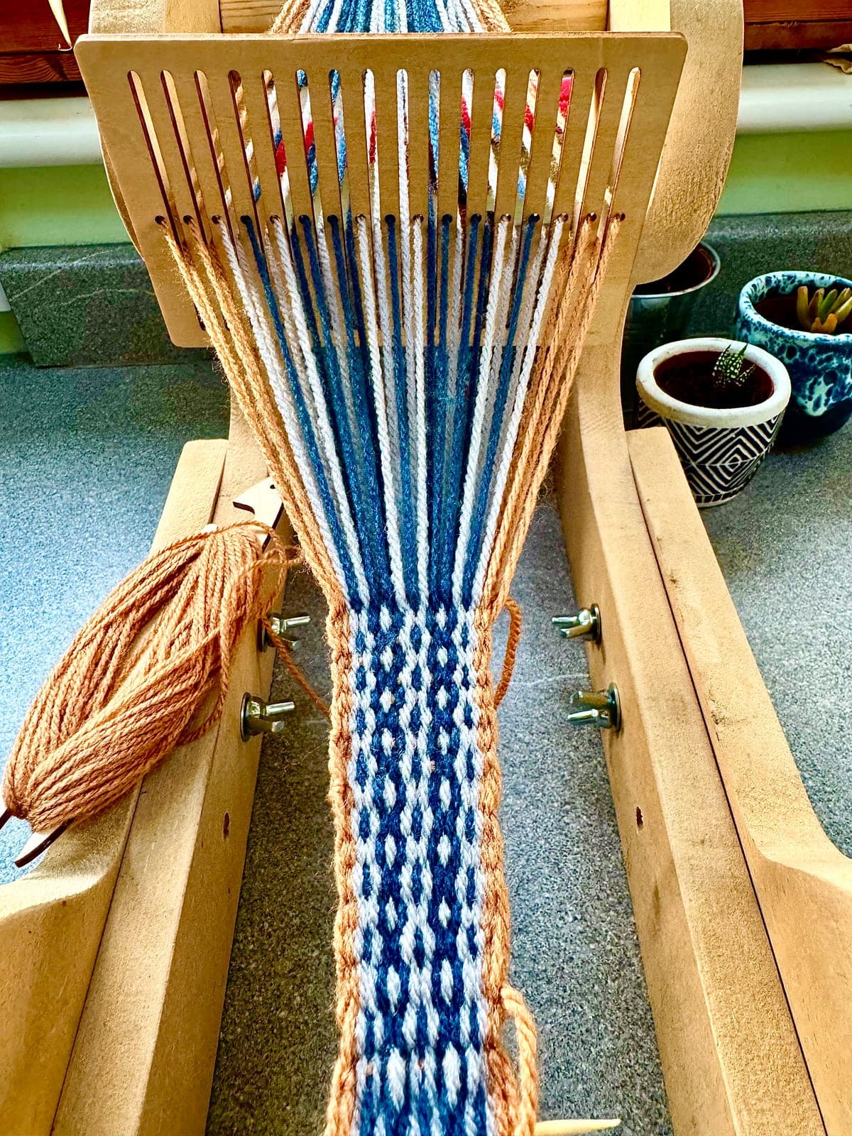 A part-woven patterned band on a rigid heddle loom